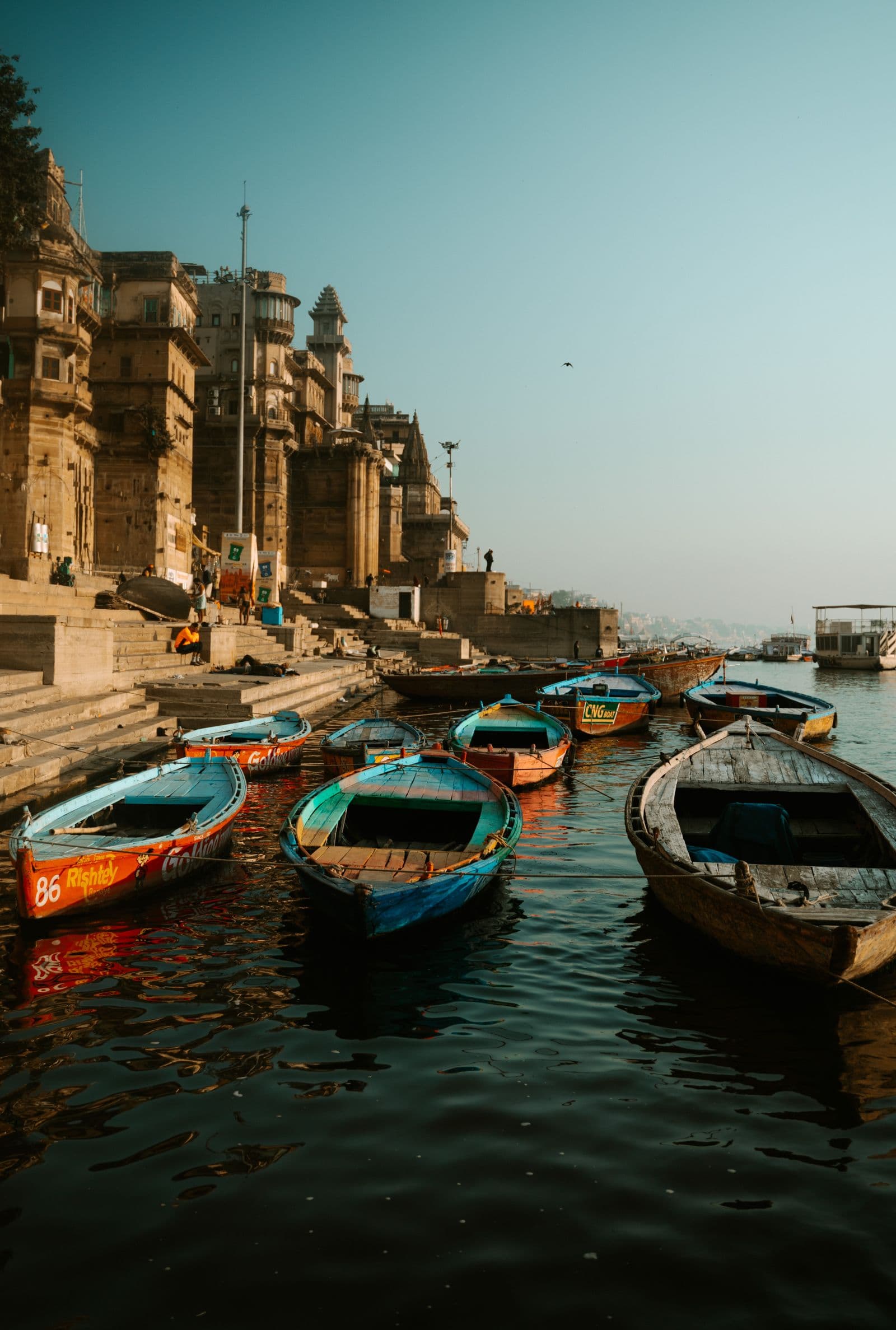 Wooden boats moored below the ghats in clear morning light