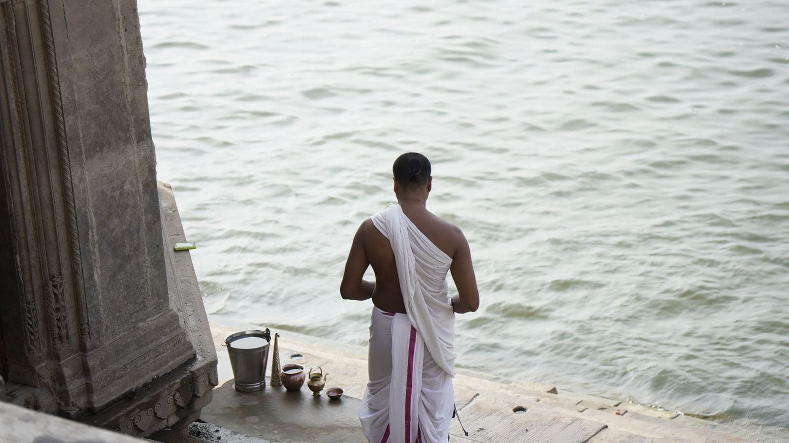 A priest at the edge of the Ganga at dawn